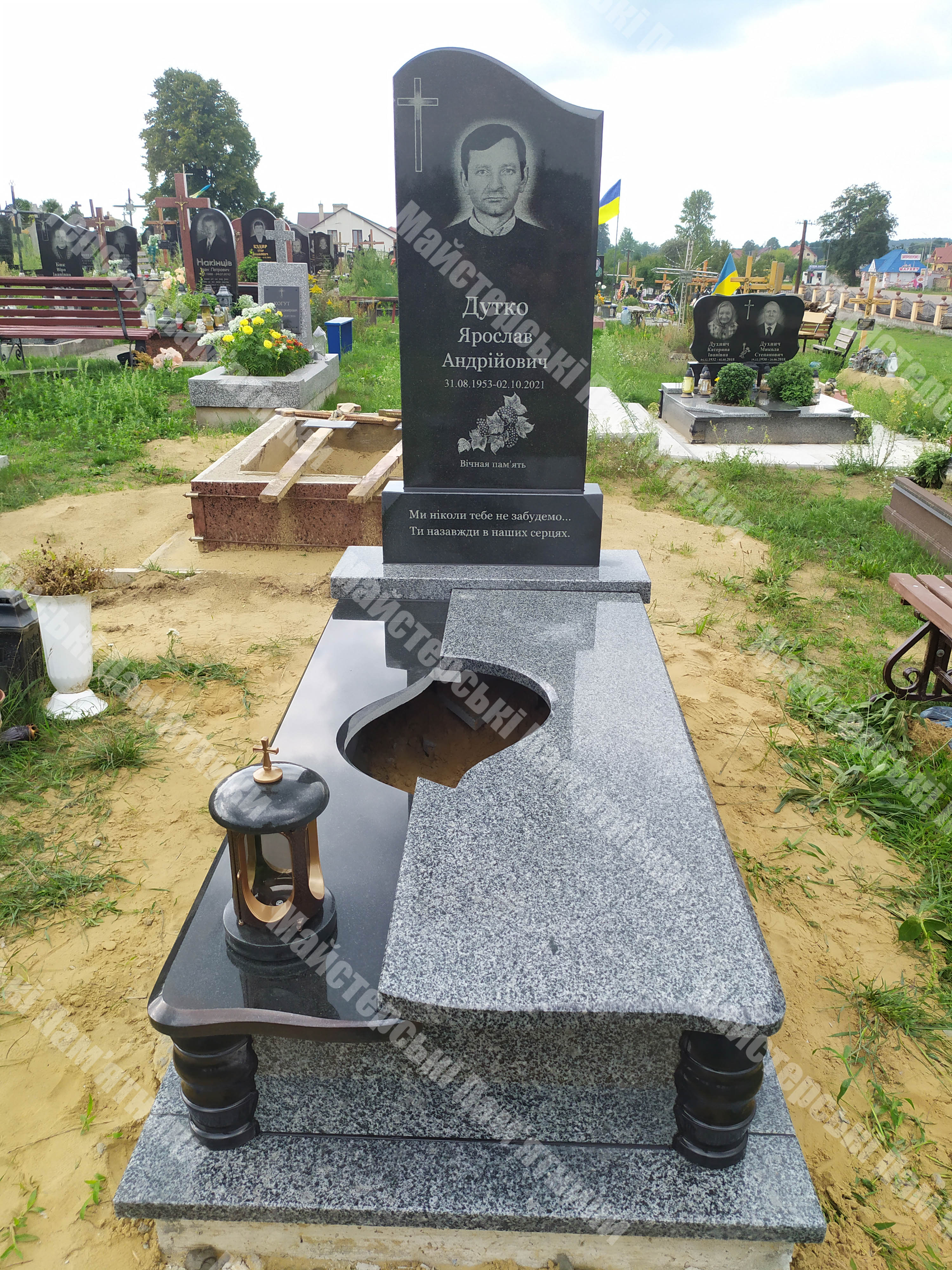 одиночний пам’ятник з покостівського граніту, з отвором у нижній плиті та декоративною лампаткою